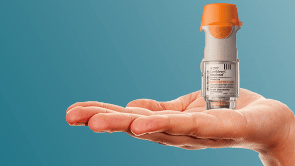 A COMBIVENT RESPIMAT inhaler standing upright on someone's hand
